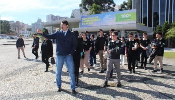Rofolfo Revers, presidente da Câmara de Vereadores de Quedas do Iguaçu acompanhando os vereadores mirins e integrantes do Parlamento Jovem em frente a Assembleia Legislativa do Paraná (Foto: Ascom/CMQI)