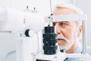 Senior patient checking vision with special eye equipment