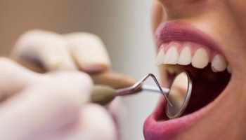 dentist-examining-female-patient-with-tools-1024x683.jpg